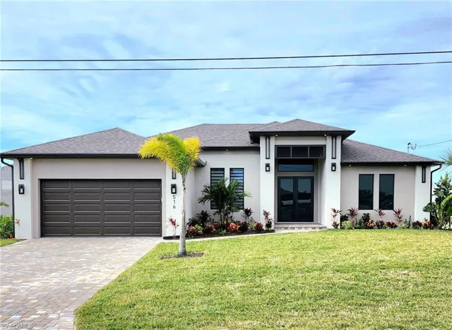 Prairie-style home with french doors, a front lawn, and a garage