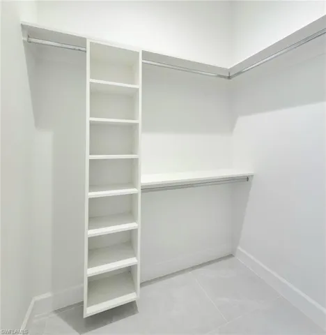 Spacious closet with light tile patterned floors