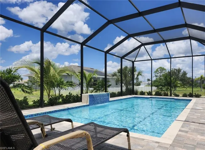 View of pool with pool water feature, a lanai, and a patio area
