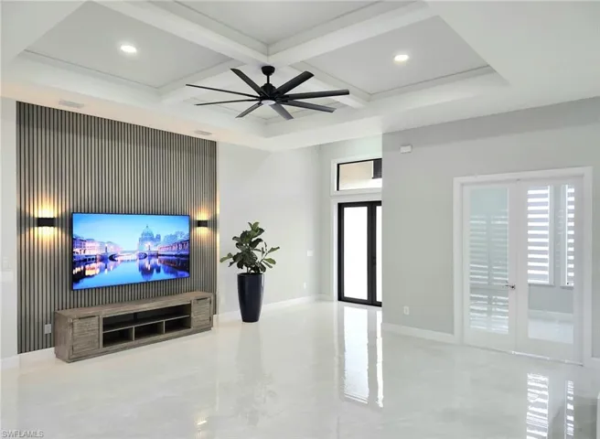 Living room featuring beamed ceiling, ceiling fan, french doors, and coffered ceiling