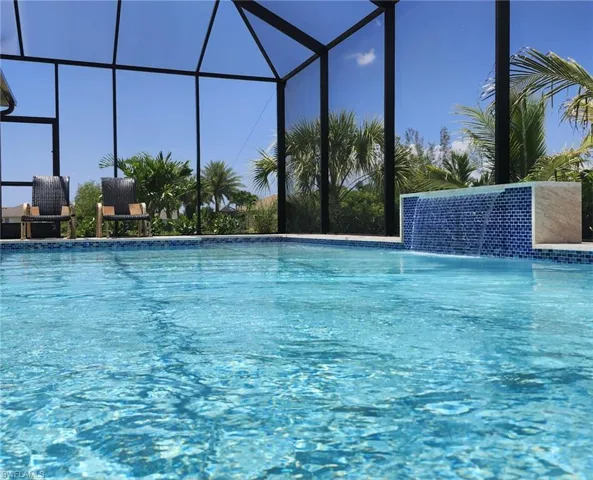 View of swimming pool with glass enclosure and pool water feature
