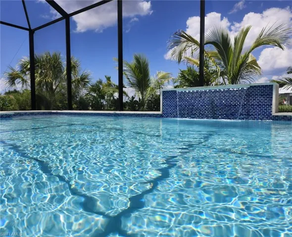 View of swimming pool featuring pool water feature and glass enclosure