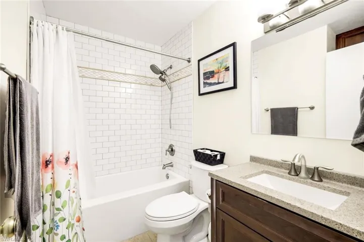 Full bath featuring vanity and shower / bath combination with curtain