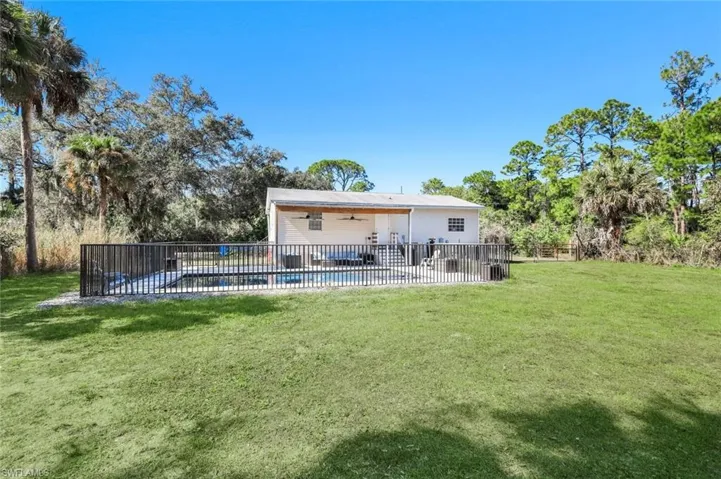 Rear view of property with ceiling fan and a patio area