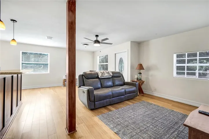 Living room featuring light wood-type flooring, plenty of natural light, and ceiling fan