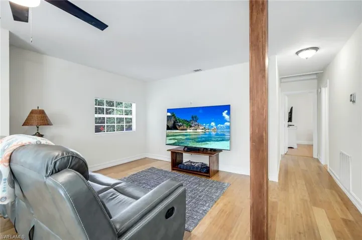 Living room with light wood-style floors and ceiling fan
