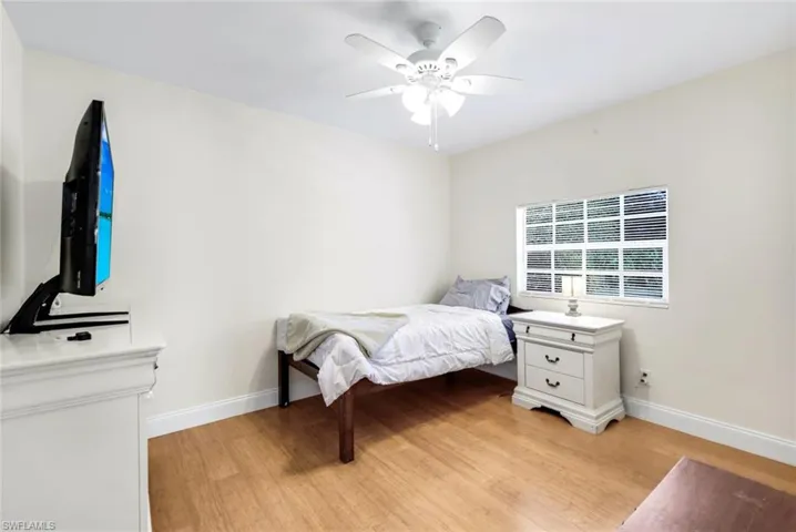 Bedroom with light wood finished floors and a ceiling fan