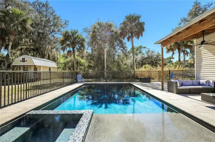 View of swimming pool with a patio, outdoor lounge area, a fenced backyard, and a pool with connected hot tub