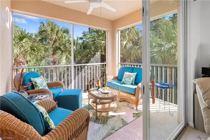 Screened balcony with a ceiling fan, featuring a tropical landscape backdrop