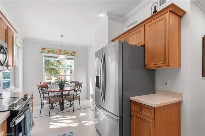 Bright kitchen and dining area featuring light-toned cabinetry, light countertops, and tile flooring