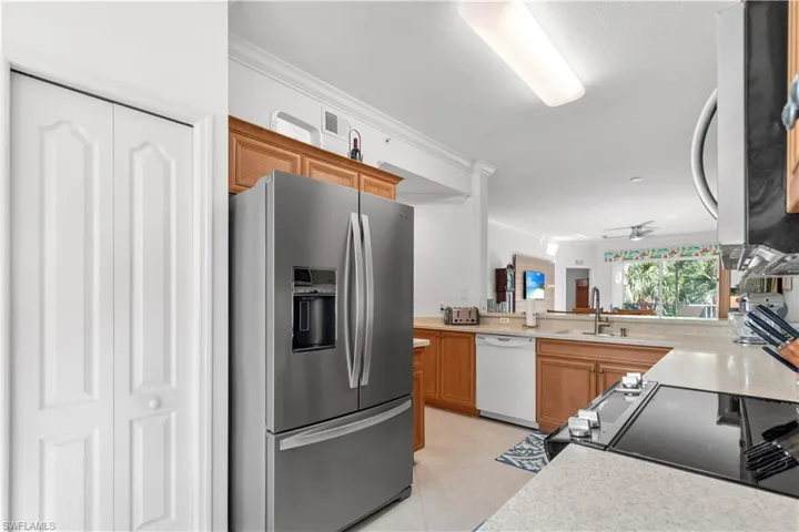 Kitchen featuring a pantry, stainless steel French door refrigerator, and light wood-finish cabinetry
