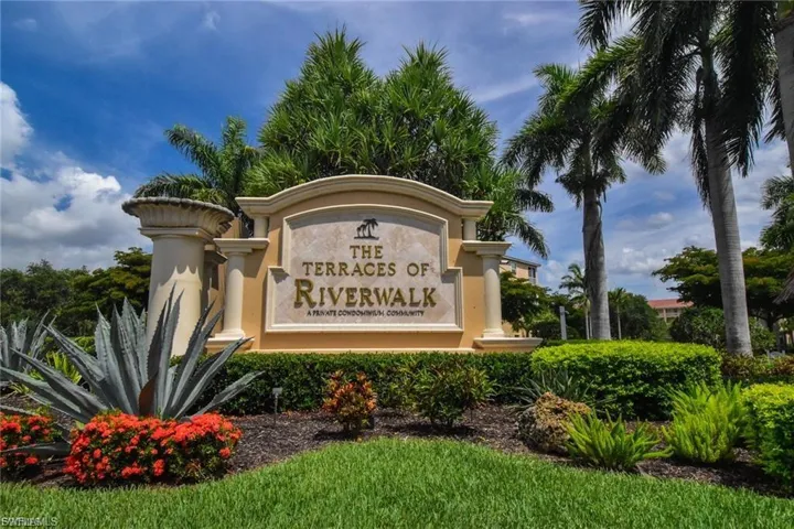 Community entrance sign for "The Terraces of Riverwalk" surrounded by tropical landscaping