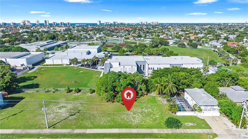 Vacant lot featuring cleared grounds, mature trees, and proximity to paved street access