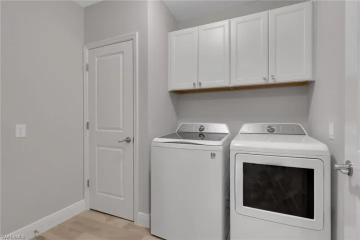 Laundry area featuring washing machine and dryer and cabinet space
