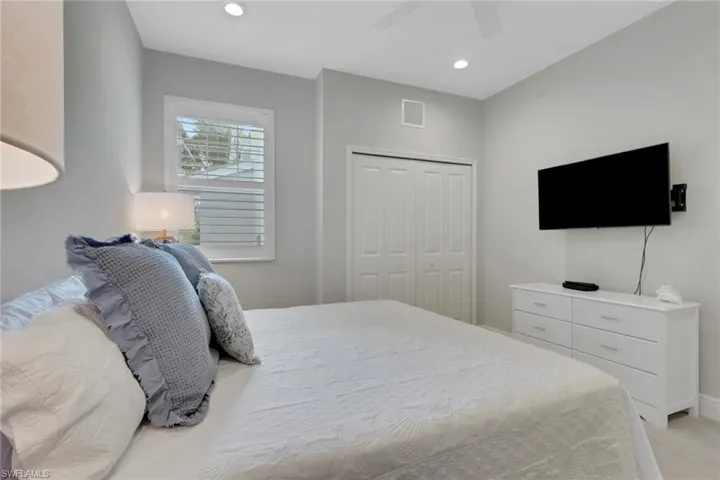 Bedroom with a closet, a ceiling fan, recessed lighting, and light colored carpet