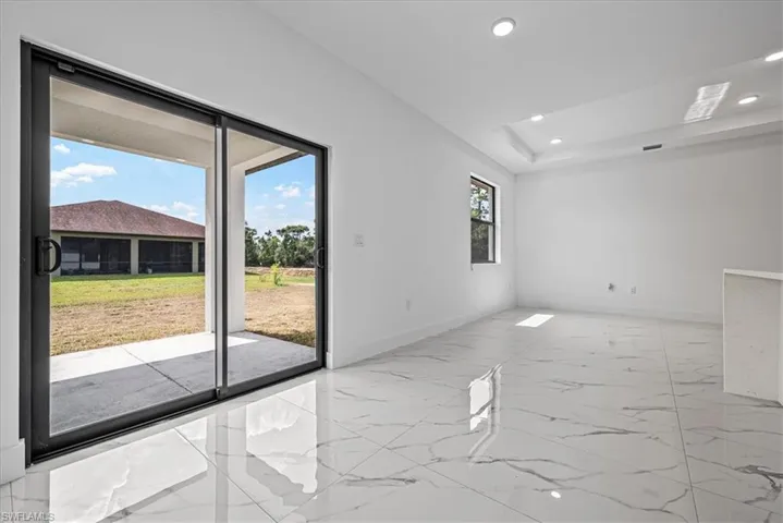 Spare room with recessed lighting, light marble finish floors, and a raised ceiling