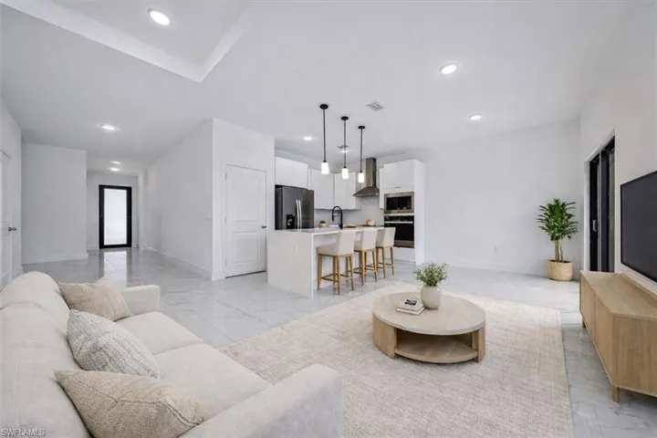 Living area featuring light marble finish flooring and recessed lighting
