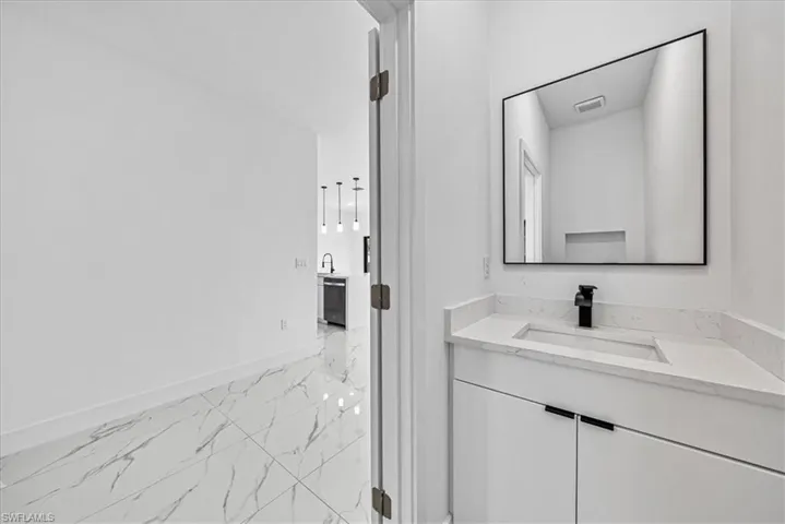 Bathroom featuring vanity and light marble finish flooring