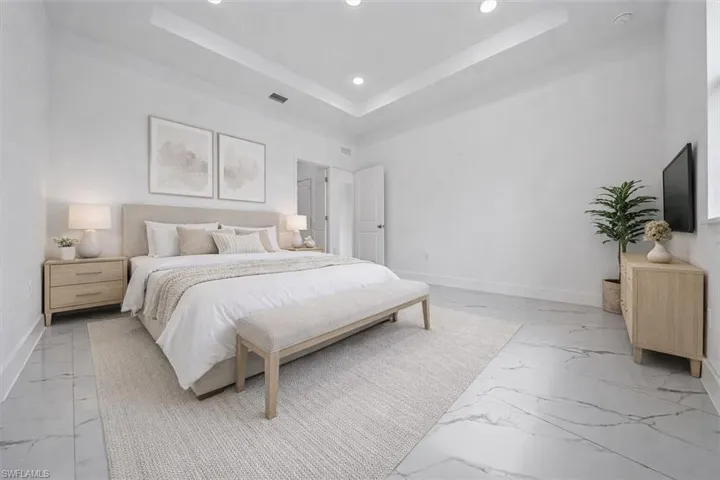 Bedroom featuring a tray ceiling and recessed lighting