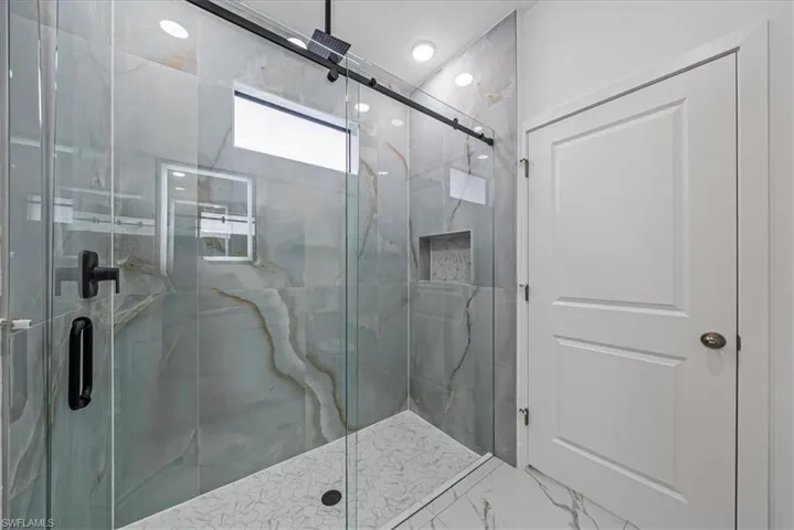Full bathroom featuring a marble finish shower and marble finish flooring