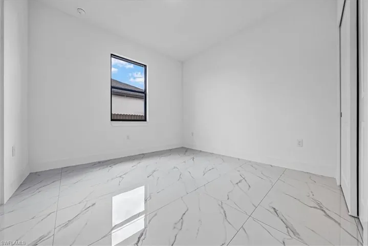 Empty room featuring light marble finish floors and baseboards