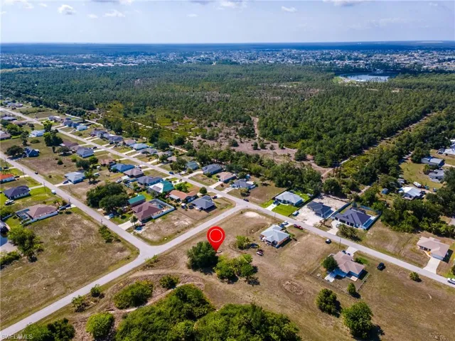 Aerial view of property and surrounding area featuring a forest