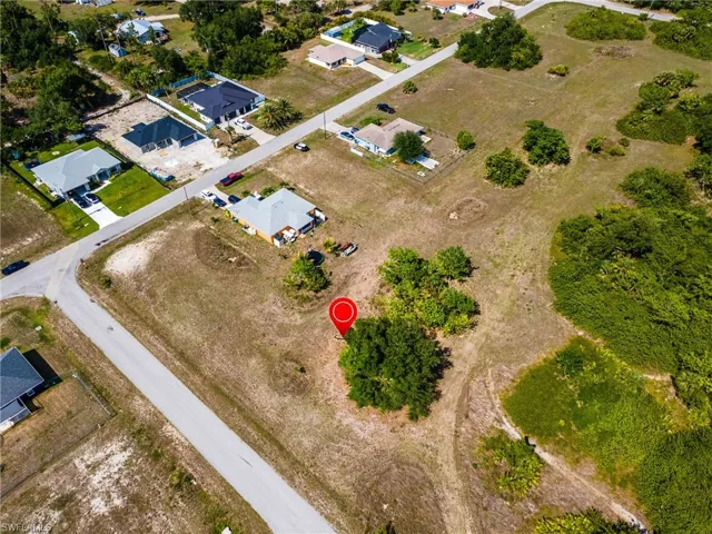 Aerial view of property and surrounding area featuring nearby suburban area
