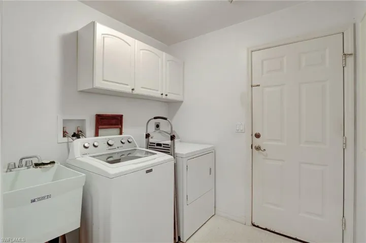 Laundry area with washer and dryer, light tile flooring, washer hookup, sink, and cabinets