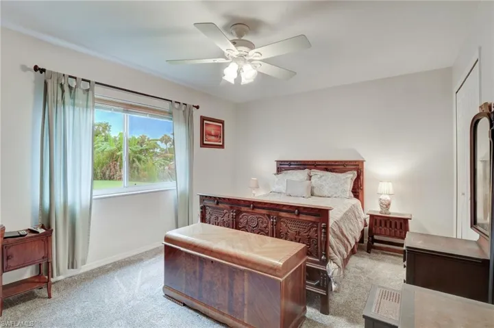 Carpeted bedroom featuring ceiling fan