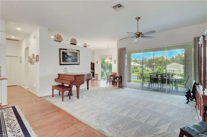 Living room featuring ceiling fan and light wood-type flooring leads to kitchen and 2 split bedrooms