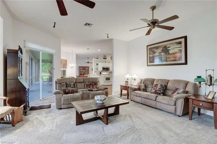 Carpeted living room featuring ceiling fan