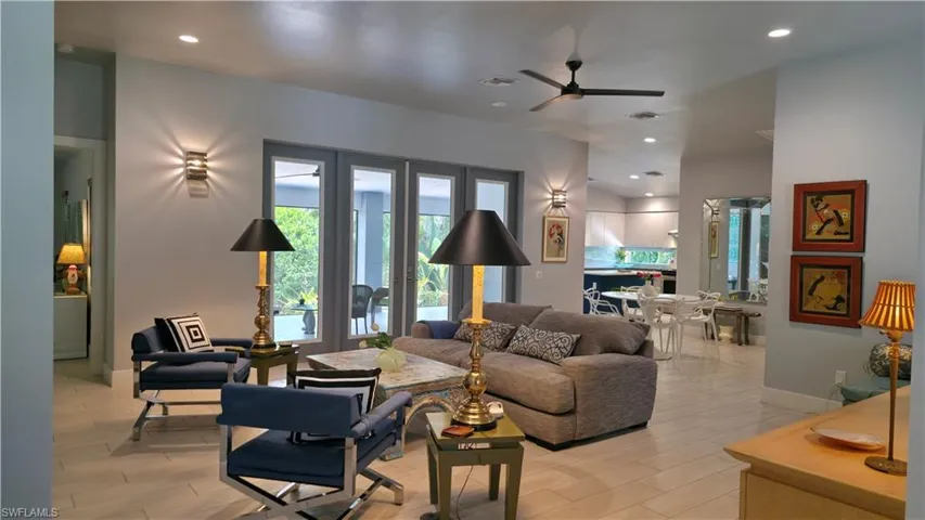 Living area featuring light tone flooring, a ceiling fan, and recessed lighting
