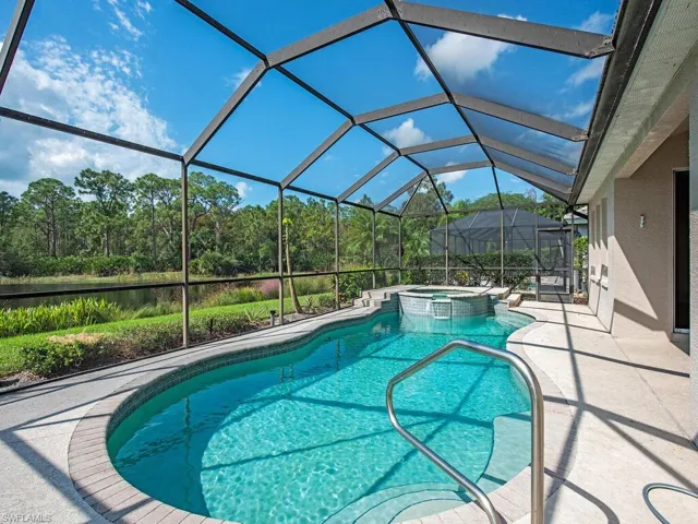 View of pool with an in ground hot tub, a patio, and a lanai