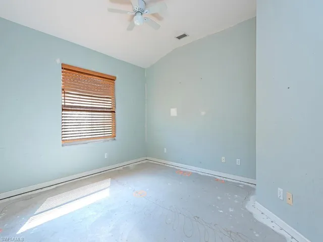 Unfurnished room with lofted ceiling and ceiling fan