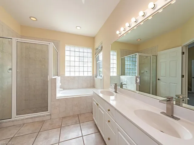 Bathroom with vanity, tile patterned floors, and separate shower and tub