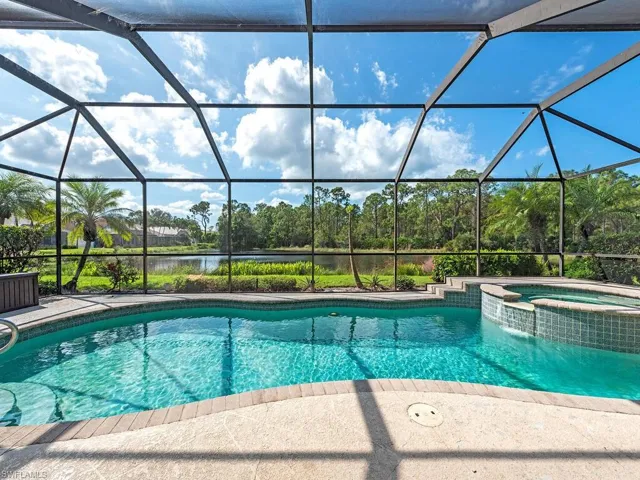 View of swimming pool with an in ground hot tub and glass enclosure