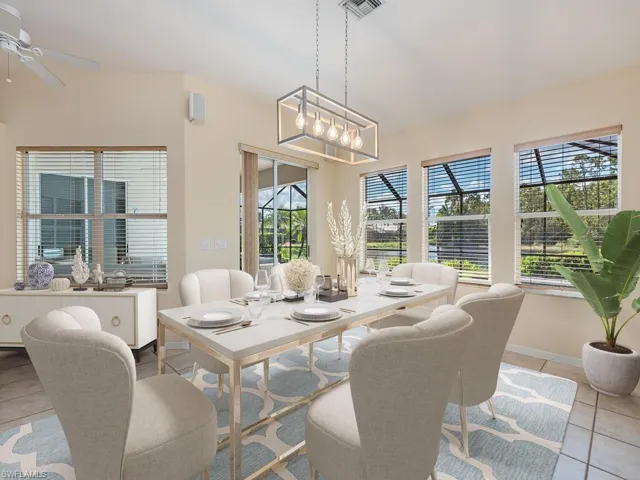 Dining room featuring ceiling fan with notable chandelier and light tile patterned floors