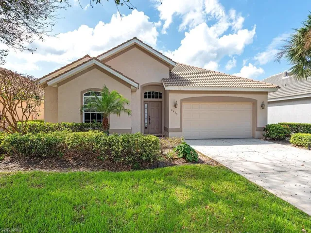 Mediterranean / spanish-style home with a front yard and a garage