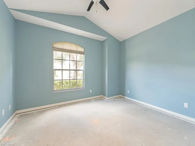 Spare room featuring ceiling fan and vaulted ceiling