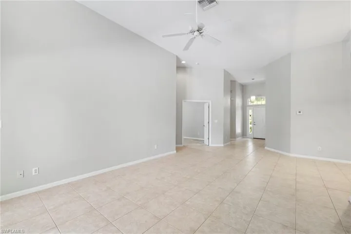 Tiled spare room featuring ceiling fan