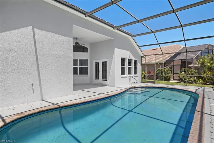 View of swimming pool featuring ceiling fan, a lanai, and a patio area