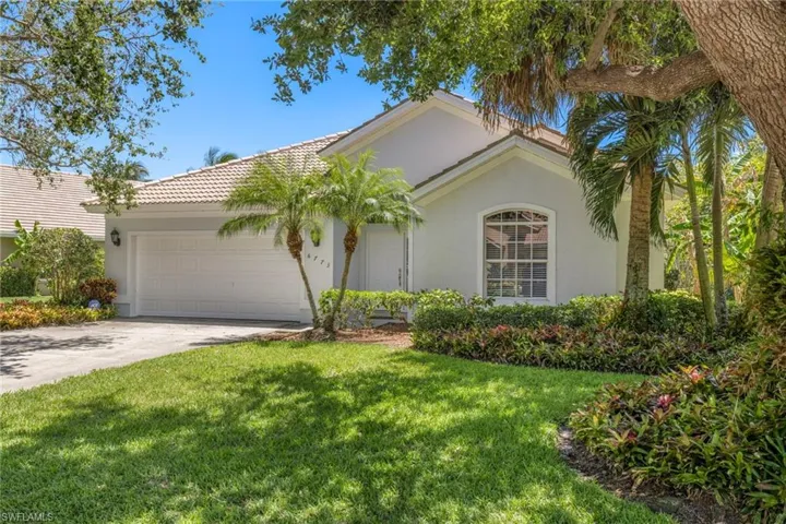 View of front of property with a front yard and a garage