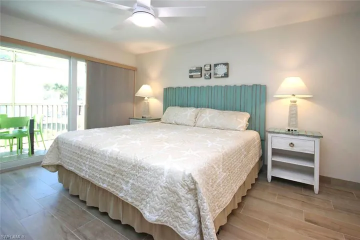 Bedroom featuring wood finish floors, ceiling fan, and access to outside
