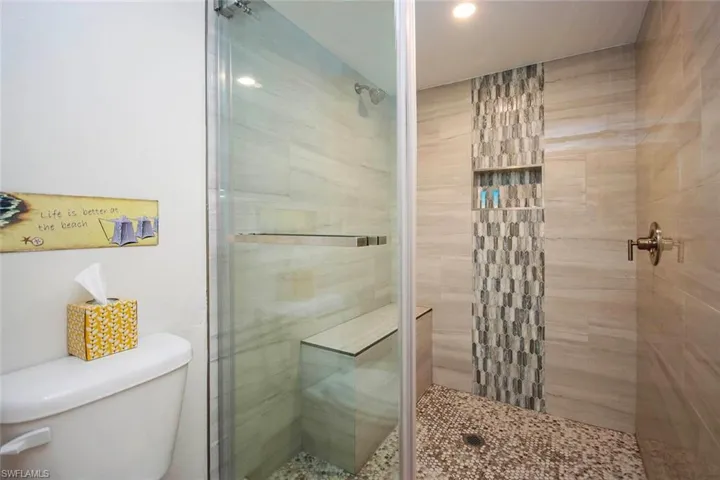 Full bathroom with toilet and a stall shower