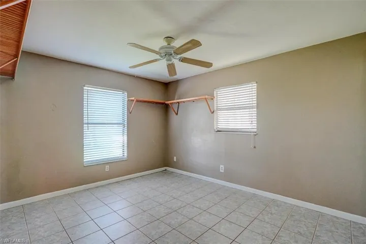 Tiled spare room with ceiling fan and plenty of natural light