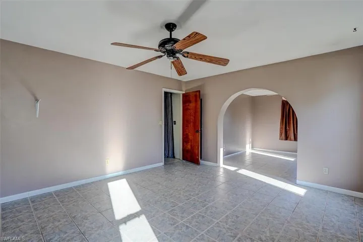 Unfurnished room with light tile patterned floors and ceiling fan