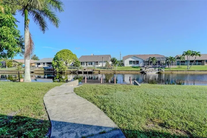 Surrounding community featuring a water view and a yard