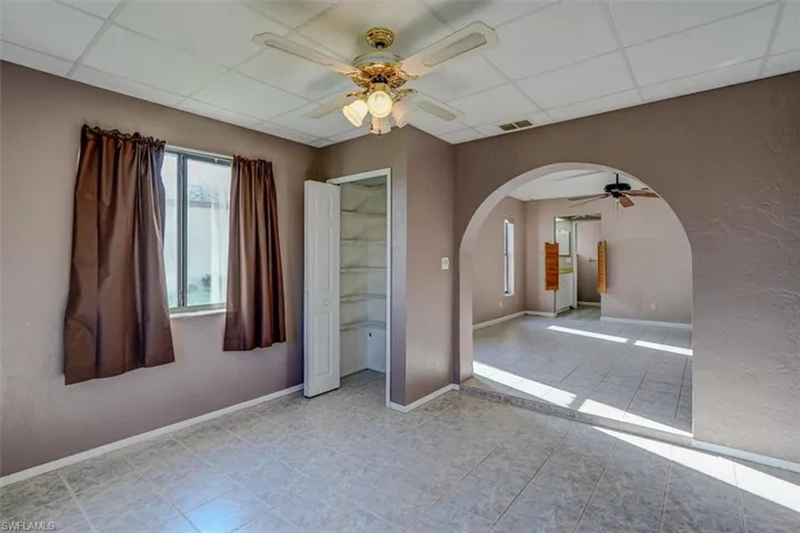 Nursery/sitting area in Primary bedroom featuring ceiling fan, a closet, a paneled ceiling, and light tile floors