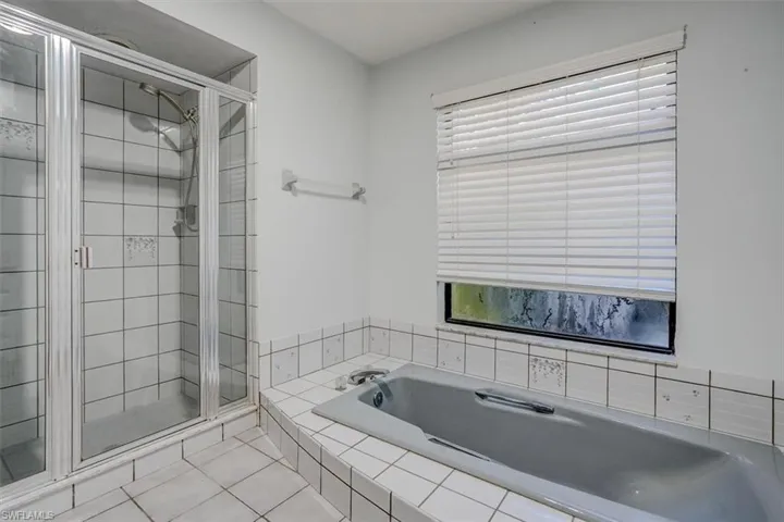 Bathroom featuring tile patterned floors and plus walk in shower