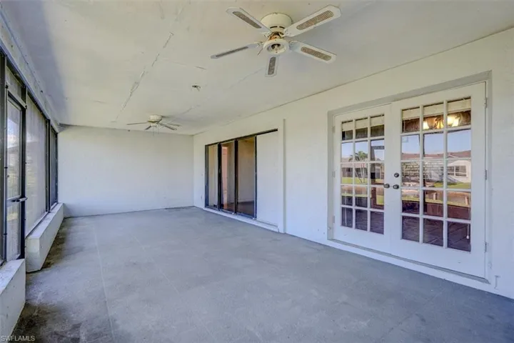 Unfurnished sunroom with ceiling fan and french doors